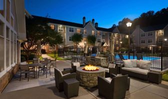 Patio area with fire pit, barbecue, tables and chairs, and armchairs, at Sonesta ES Suites Atlanta Alpharetta North Point Mall.