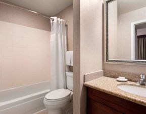 Sonesta ES Suites Tempe guest bathroom, fitted with shower-equipped bath, lavatory, mirror, and sink.