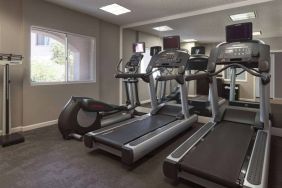 Sonesta ES Suites Tempe’s fitness center has a window, mirrored wall, treadmills, and an elliptical machine.