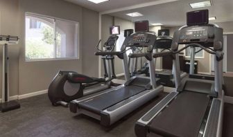 Sonesta ES Suites Tempe’s fitness center has a window, mirrored wall, treadmills, and an elliptical machine.