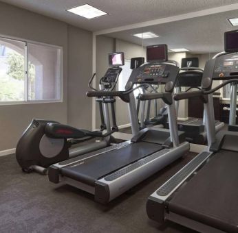 Sonesta ES Suites Tempe’s fitness center has a window, mirrored wall, treadmills, and an elliptical machine.