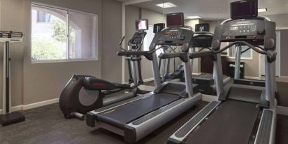 Sonesta ES Suites Tempe’s fitness center has a window, mirrored wall, treadmills, and an elliptical machine.