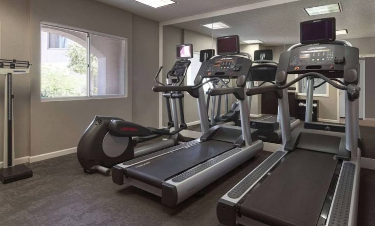 Sonesta ES Suites Tempe’s fitness center has a window, mirrored wall, treadmills, and an elliptical machine.