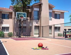 The hotel basketball court has fencing by the hoop, and can also be used for playing tennis.