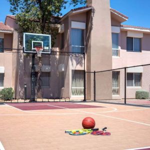 The hotel basketball court has fencing by the hoop, and can also be used for playing tennis.