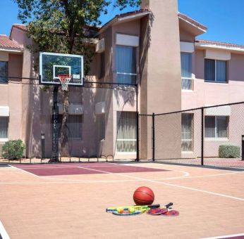 The hotel basketball court has fencing by the hoop, and can also be used for playing tennis.