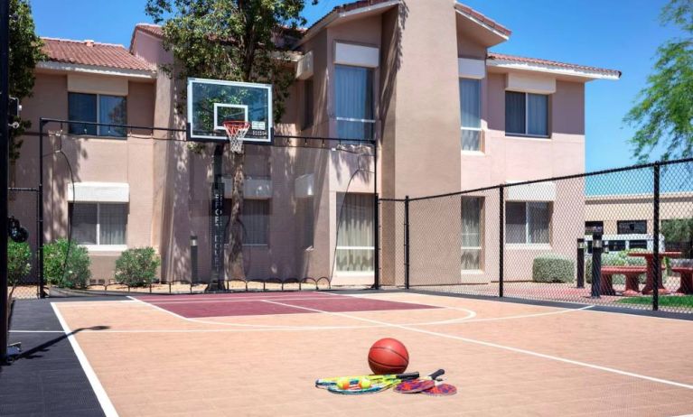 The hotel basketball court has fencing by the hoop, and can also be used for playing tennis.