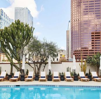 Relaxing outdoor pool with pool chairs at Hotel Figueroa.