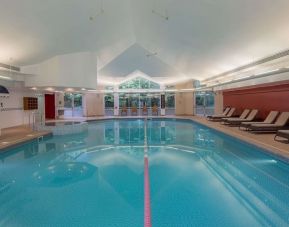 Indoor pool with pool chairs at Hilton Leicester.