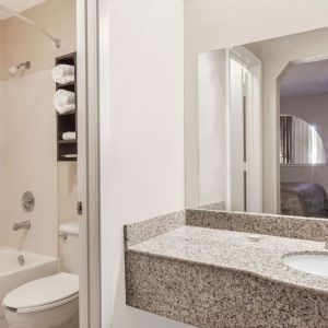 Guest bathroom with shower and bath at Super 8 By Wyndham Houston/Webster.