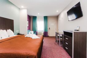 King bed with TV and natural light at Express Inn - Spring.