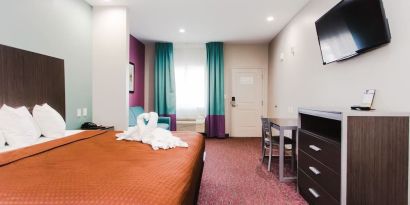 King bed with TV and natural light at Express Inn - Spring.