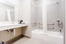 Guest bathroom with shower and bath at Express Inn - Spring.