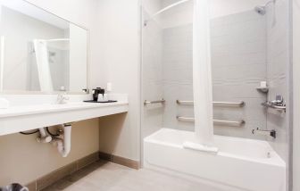 Guest bathroom with shower and bath at Express Inn - Spring.