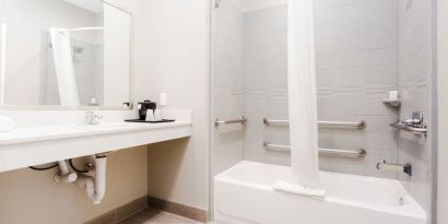 Guest bathroom with shower and bath at Express Inn - Spring.