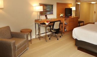 King bed with couch and work space at EnVision Hotel And Conference Center Mansfield Foxboro.