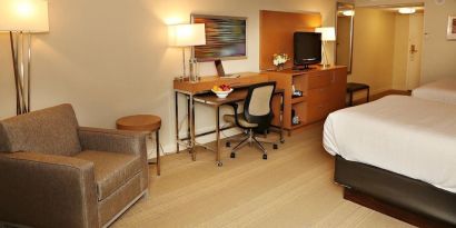 King bed with couch and work space at EnVision Hotel And Conference Center Mansfield Foxboro.