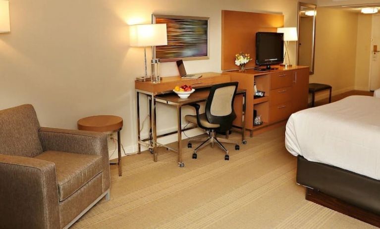 King bed with couch and work space at EnVision Hotel And Conference Center Mansfield Foxboro.