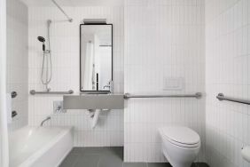 Guest bathroom with shower and bath at Arlo SoHo.
