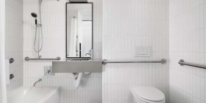 Guest bathroom with shower and bath at Arlo SoHo.
