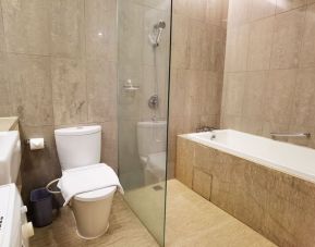 Bathroom with bath and shower at Fraser Residence Menteng Jakarta.