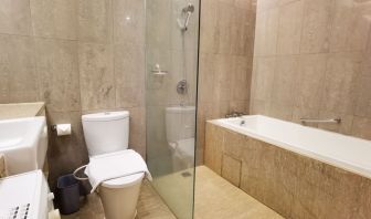 Bathroom with bath and shower at Fraser Residence Menteng Jakarta.