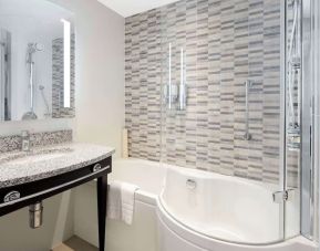 Guest bathroom with shower and bathat Hampton By Hilton London Stansted Airport.