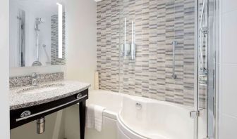 Guest bathroom with shower and bathat Hampton By Hilton London Stansted Airport.