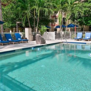 Large outdoor pool with sun lounge chairs at Sonesta ES Suites Fort Lauderdale Plantation.