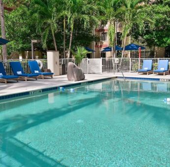 Large outdoor pool with sun lounge chairs at Sonesta ES Suites Fort Lauderdale Plantation.