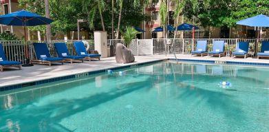 Large outdoor pool with sun lounge chairs at Sonesta ES Suites Fort Lauderdale Plantation.