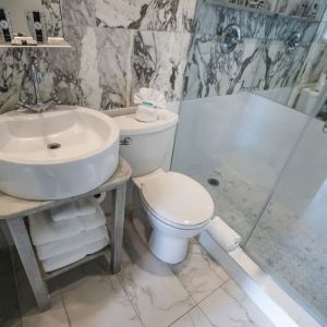 Guest bathroom with shower at Chesterfield Hotel & Suites.