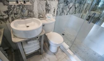 Guest bathroom with shower at Chesterfield Hotel & Suites.