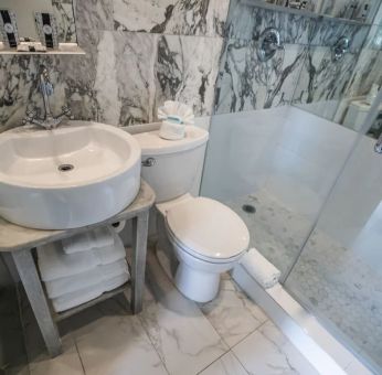 Guest bathroom with shower at Chesterfield Hotel & Suites.