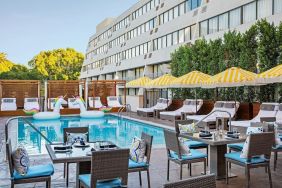 Outdoor pool with surrounding seating area at Hotel Dena, Pasadena Los Angeles.