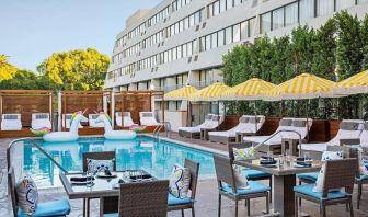 Outdoor pool with surrounding seating area at Hotel Dena, Pasadena Los Angeles.