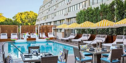 Outdoor pool with surrounding seating area at Hotel Dena, Pasadena Los Angeles.