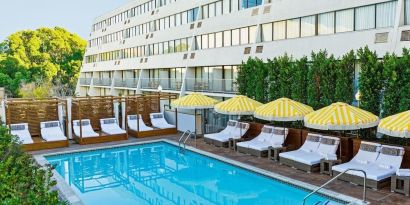 Relaxing outdoor pool with pool loungers at Hotel Dena, Pasadena Los Angeles.