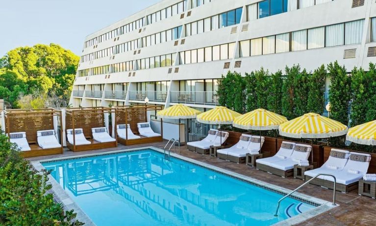 Relaxing outdoor pool with pool loungers at Hotel Dena, Pasadena Los Angeles.