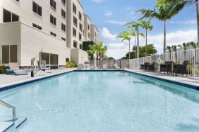 Outdoor pool with chairs at Hampton Inn & Suites Miami Kendall. 