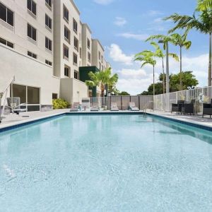 Outdoor pool with chairs at Hampton Inn & Suites Miami Kendall. 