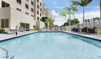 Outdoor pool with chairs at Hampton Inn & Suites Miami Kendall. 