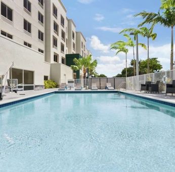 Outdoor pool with chairs at Hampton Inn & Suites Miami Kendall. 