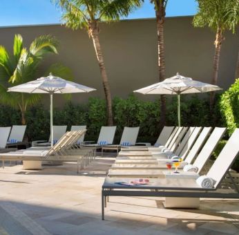 Outdoor pool with pool chairs at Sonesta Fort Lauderdale Beach.