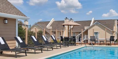 Outdoor pool with pool chairs at Sonesta ES Suites Cincinnati - Blue Ash.