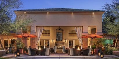 Hotel exterior with outdoor seating at Sonesta Suites Scottsdale Gainey Ranch.