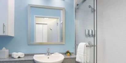 Guest bathroom with shower at Sonesta ES Suites New Orleans.