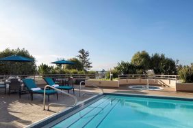 Outdoor pool with seating area at Sonesta San Jose.