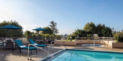 Outdoor pool with seating area at Sonesta San Jose.