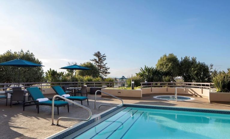 Outdoor pool with seating area at Sonesta San Jose.